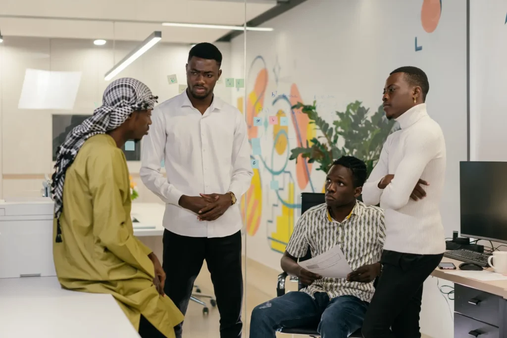 Four colleagues talking in a bright, modern office