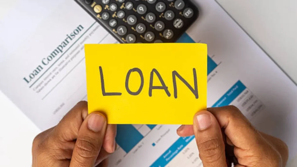A yellow note that says loan, held over a loan comparison and a calculator